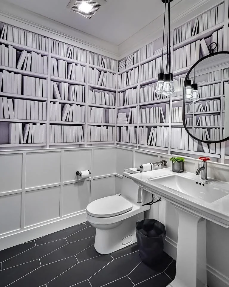Modern bathroom with white cabinetry, pedestal sink, and dark herringbone tile flooring
