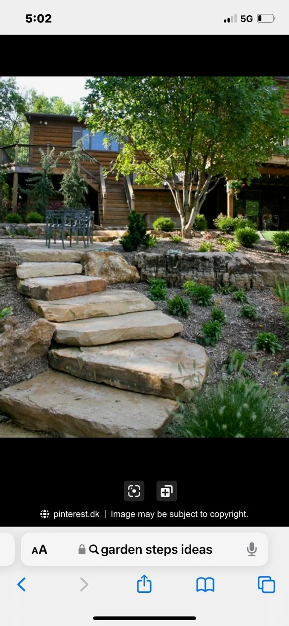 Natural stone steps with retaining walls leading to modern wood house with mature trees