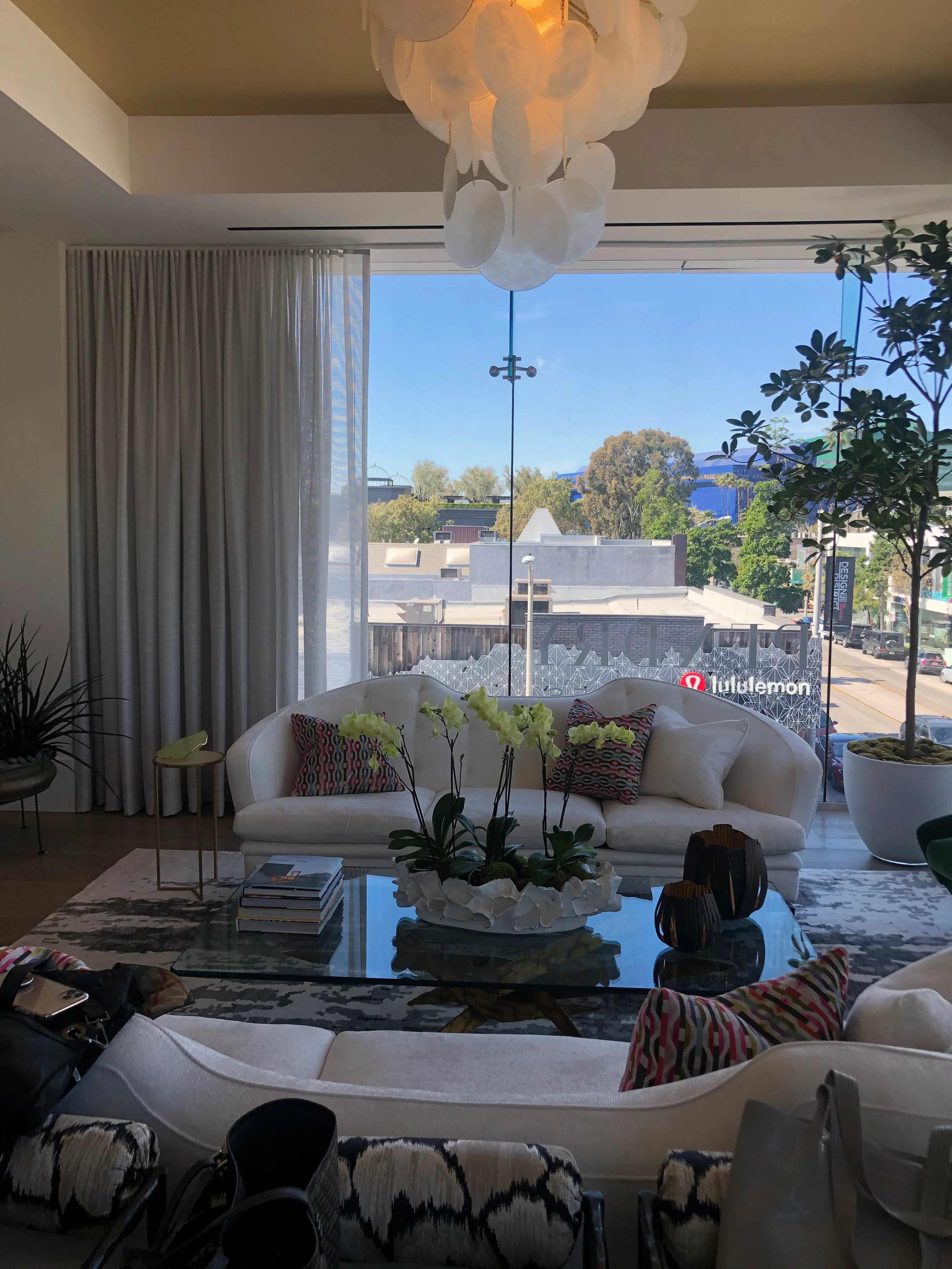 Modern living room with floor-to-ceiling windows, white sofa, and city views