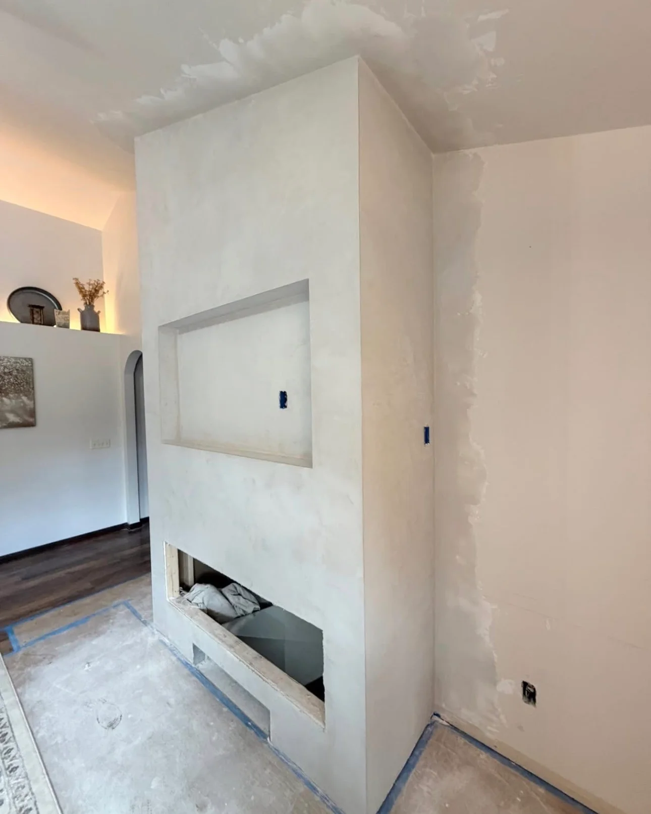 White drywall fireplace feature wall with recessed opening and display niche during construction