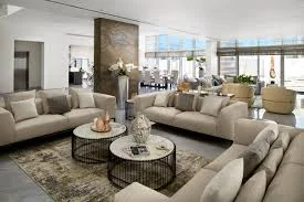 Modern living room with cream upholstered seating, geometric wood tables, and contemporary design elements