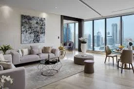 Modern high-rise living room with marble floors, neutral seating, and city views