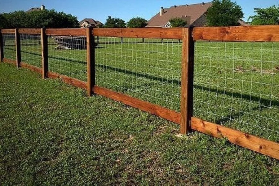 Wood-framed wire mesh fencing with timber posts along residential property